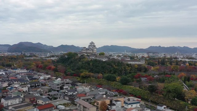 Aerial view of famous Himaji Castle, picturesque autumn scenery with medieval fortress complex and trees of many colors - landscape panorama of Japan from above, Asia