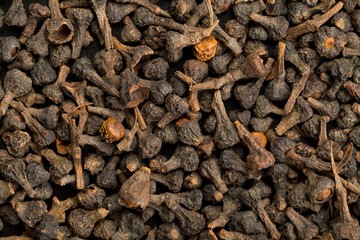 Raw, dried cinnamon blossom buds spice top view flat lay frame filling background