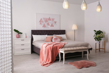 Stylish room interior with large comfortable bed