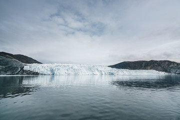 Greenland Glacier with Sea Ice and a Glacial Landscape near the Eqip Sermia Glacier, Eqi in Western Greenland near arctic town of Ilulissat. Blue sky on a sunny day. Calving Glacier.