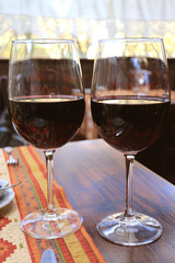 Vertical image of two glasses of red wine on the table in restaurant