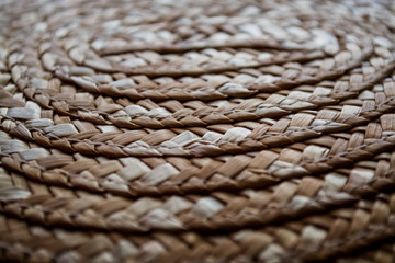 Background or texture from the weaving of straw on a straw hat. Circles and strips. Braid.