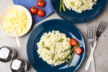 Delicious risotto with asparagus on grey table, flat lay