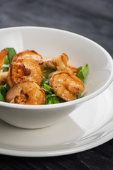 Fried shrimps with yogurt sauce and greens on plate