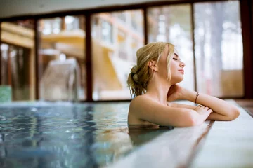 Fotobehang Young woman relaxing in spa swimming pool © BGStock72
