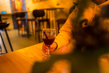 Woman holds a glass of mulled wine.