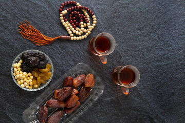 Obraz na płótnie Canvas food Ramadan Sweets dried fruits and nuts Tea with a rosary and the on the table white, Concept: month fasting culture Muslim and prayer for god, Ramadan food symbolic eastern Arabian