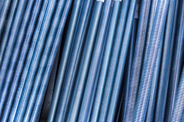 Threaded metal rods. Technological background or texture. A number of threaded steel rods, may be used as background.