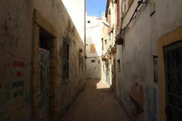 Fototapeta na wymiar Between the beautiful houses in the old town of Moroccos cities. The sun is shining into alleys that are leading into new discoveries. What can you find behind the next corner?