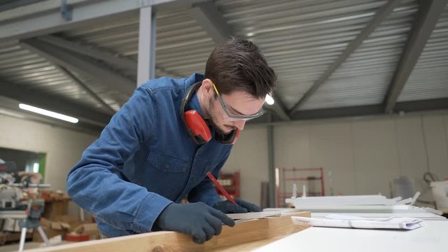 Apprentice working wood in carpentry workshop