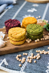 Vegan chickpea burgers cutlets or patties. Healthy vegan diet food. Mixed vegetables yellow pumpkin, orange carrot, green spinach and red beet chickpea cutlets.