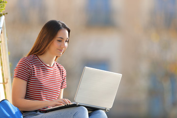 Student learning using laptop sitting in a campus