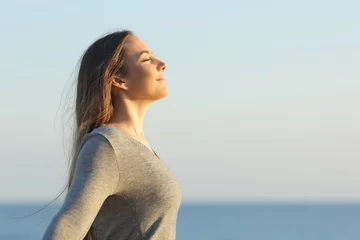 Fotobehang Woman breaths fresh air on the beach © PheelingsMedia