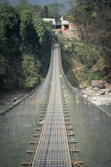 people crossing hanging bridge in nepal
