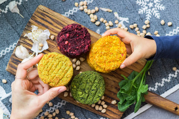 Vegan chickpea burgers cutlets or patties. Healthy vegan diet food. Adult and child hands hold vegan burger's cutlets.