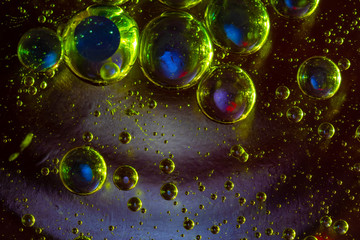 Macro photo of colored water drops suspended in oil