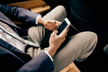 Close up of a man in car using his phone.