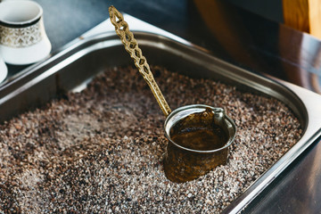 The process of brewing traditional Turkish coffee in Turk on sand