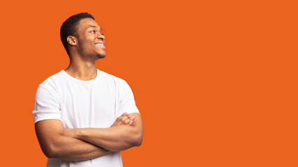 Smiling black man profile portrait on orange background - obrazy, fototapety, plakaty