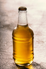 Bottle of light cold beer closeup, condensation drops on the glass on a hot day