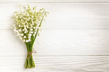 Bouquet of lily of the valley flowers on wooden background with copy space: spring time concept
