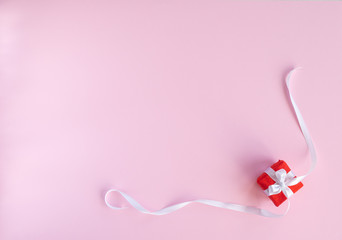 Valentines day composition. Flat lay with gift present box , red hearts, white ribbon on pink background. Top view, copy space. Greeting card. Valentine's day, birthday, wedding concept. 