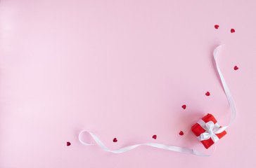 Valentines day composition. Flat lay with gift present box , red hearts, white ribbon on pink background. Top view, copy space. Greeting card. Valentine's day, birthday, wedding concept. 