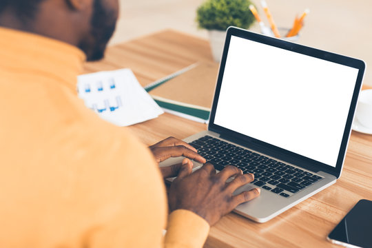 Afro businessman typing on lapop financial report