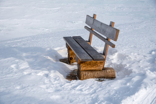 Wooden bench next to a winter hiking trail in the austrian alps in Lungau, Salzburg, Austria. © Thomas Marchhart
