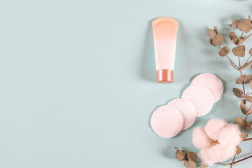 Cosmetics  makeup products - cream jar, eucalyptus leaves, cotton pads on light blue background. Natural organic skincare beauty product in minimalism style. Flat lay, top view, copy space
