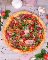 pizza with tomato and basil on wooden table