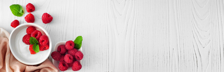 Healthy yogurt with raspberries. Banner with corner border against a rustic white wood background....