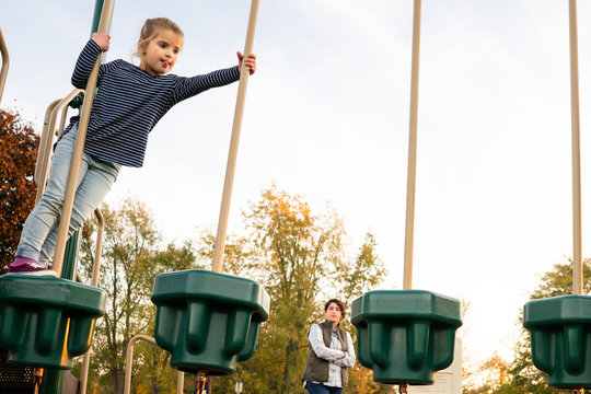 Woman supervising young child on playground at recess
