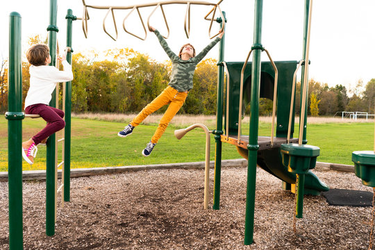 Young girls swinging on the monkey bars at a playground