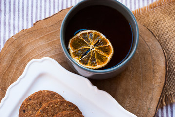 Cup of tea with slice of orange with cookies. Xmas tea.