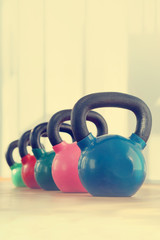 Naklejka na ściany i meble Colorful kettlebells in gym