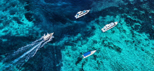 Boats on the water surface from top view. Azure water background from drone. Summer seascape from air. Travel - image © biletskiyevgeniy