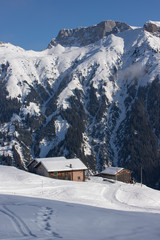 Fototapeta na wymiar Mountain huts in a snowy landscape in the swiss Alps, Switzerland, Europe