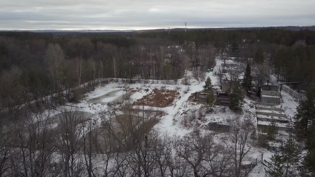 drone is flying over outbuilding in forest area in winter day