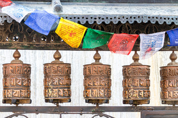 Nahansicht von Gebetsmühlen mit Gebetsfahnen an der Swayambhunath Stupa, Kathmandu, Nepal
