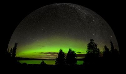Fototapeta na wymiar Bright green northern Lights (Aurora) and stars over a lake in a forested setting. Done in a snow-globe 3-D style.