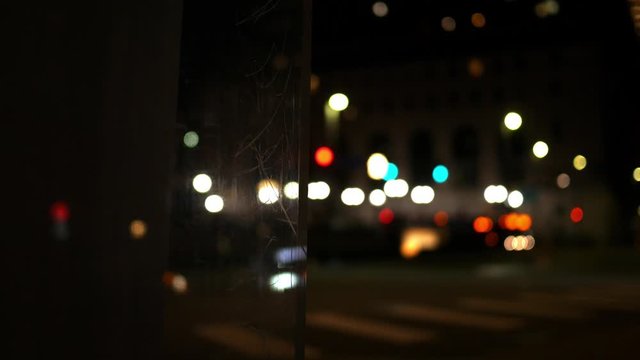 A defocused car turns at an intersection approaching a bus station