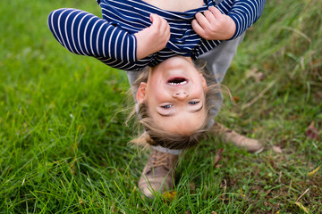 Smiling girl hanging upside down