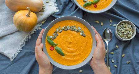 Bowl of vegetarian pumpkin carrot soup served with seeds