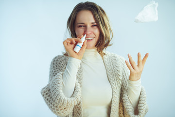 woman using nasal spray and throwing up with napkin - obrazy, fototapety, plakaty