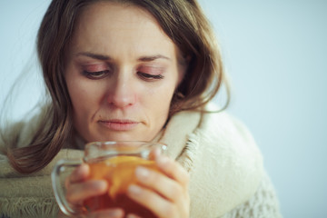 sad sick modern woman drinking cup of tea