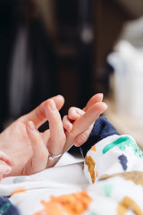 Obraz na płótnie Canvas Newborn holding mother's hand. Closeup photography of hands. 