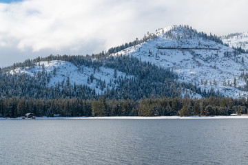 The Donner lake under the snow in winter, in the Nevada, with chalets on the beach