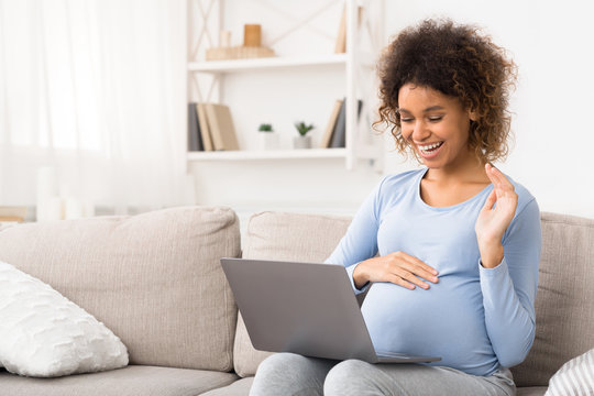 African-american Pregnant Woman Video Chatting On Laptop