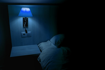 a night lamp shines by the bed